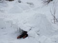 Child`s feet sticking out of the entrance to the snow house igloo Royalty Free Stock Photo