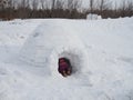 Child`s feet sticking out of the entrance to the snow house-igloo Royalty Free Stock Photo