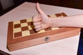 Child`s hand on the chessboard showing thumb up. cool game at home