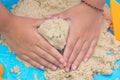 Child`s hand close up playing kinetic sand