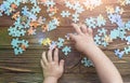 Child`s hand collects a puzzle