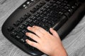 Child`s Hand on a Dirty Keyboard Playing Computer Games