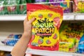 Child`s hand holding a bag of Sour Patch brand soft and chewy candy