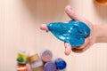 Child`s hand holding bright glitter slime. Kid playing with slime, worldwide popular self made toy.