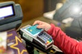 The child`s hand is holding the credit card of the Raiffeisen bank above the payment terminal to make a payment