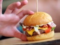 Child's hand holding juicy and yummy hamburger