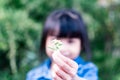 Child`s hand holding a small flower. Sharing and giving concept. Love for parents and mothersday concept. Protect kids concept