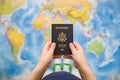 Child`s hand holding US passport. Map background. Ready for traveling. Open world Royalty Free Stock Photo