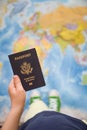 Child`s hand holding US passport. Map background. Ready for traveling. Open world Royalty Free Stock Photo