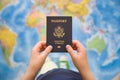 Child`s hand holding US passport. Map background. Ready for traveling. Open world Royalty Free Stock Photo