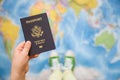 Child`s hand holding US passport. Map background. Ready for traveling. Open world Royalty Free Stock Photo