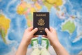 Child`s hand holding US passport. Map background. Ready for traveling. Open world Royalty Free Stock Photo