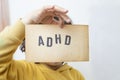 Child's hand, holding a vintage paper page with the abbreviation ADHD