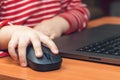 Child`s hand holds a computer mouse, child learns and plays on the computer Royalty Free Stock Photo
