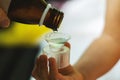 A child`s hand holds a measuring cup for cough syrup close-up. The mother pours medicine or antipyretic from a bottle into a spoon Royalty Free Stock Photo