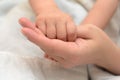 A child`s hand holds Mom by the finger. Royalty Free Stock Photo