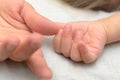 A child`s hand holds Mom by the finger. Royalty Free Stock Photo