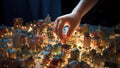 Child\'s hand hovering over a detailed miniature city model on a table, illuminated at night