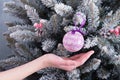 A child`s hand insures a balloon toy from falling from a Christmas tree branch