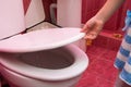 Child`s hand lifts lid of the toilet, close-up