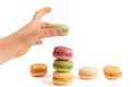 Child`s hand placing green macaron.