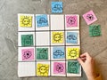 A child`s hand plays a logical game of Sudoku, rearranging bright cards.