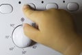 A child& x27;s hand presses a button on a washing machine Royalty Free Stock Photo