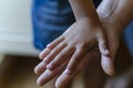 A childs hand rests on top of an adult palm