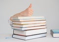 Child`s hand is on a stack of books shows a thumb up Royalty Free Stock Photo