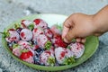 The child`s hand takes a frozen berry - strawberry blackberry. Into a bowl there are strawberries and blackberries Royalty Free Stock Photo