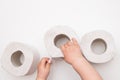 The child`s hand takes out of the pile of toilet paper on white background. copy space