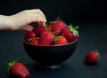 Child`s hand taking a strawberry Royalty Free Stock Photo