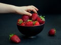 Child`s hand taking a strawberry Royalty Free Stock Photo