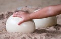 Child's hand touching ostrich egg on the sand Royalty Free Stock Photo