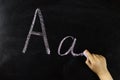 child's hand writes the letter A on the board Royalty Free Stock Photo