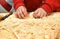 Child`s hands on the background of a handful of dry technological chips. Selective focus. Remains of woodworking, untreated wood