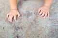 The child's hands on the concrete floor