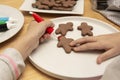 Child& x27;s hands decorating a christmas gingerbread cookies using colored glazeon, wooden table, top view. Christmas cookies Royalty Free Stock Photo