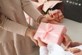 Child`s hands hold beautiful pink gift box with ribbon. Pink tulip flower and sign i love you mom in background. Top view, close- Royalty Free Stock Photo