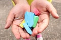 The child`s hands hold colorful crayons, top view-the concept of exciting outdoor activities