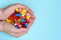 Child`s hands hold many colorful vitamins, capsules, supplements, pills