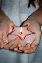 Child`s hands holding candle christmas star in night sign of hope concept Royalty Free Stock Photo
