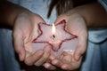 Child`s hands holding candle christmas star in night sign of hope concept Royalty Free Stock Photo