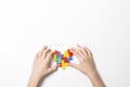 Child hands holding colorful heart on white background. World autism awareness day concept