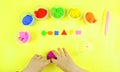 Child`s hands made colored geometric shapes . Yellow background. Masterclass for school and kindergarten.