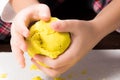 A child`s hands playing with yellow magic sand and building, kne