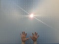 Child`s hands with ray of light through bored panel