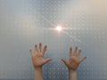 Child`s hands with ray of light through bored panel