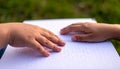 Child's Hands Reading Braille Script on White Paper Outdoors Royalty Free Stock Photo