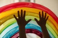 Child`s hands touch painting rainbow on the window Royalty Free Stock Photo